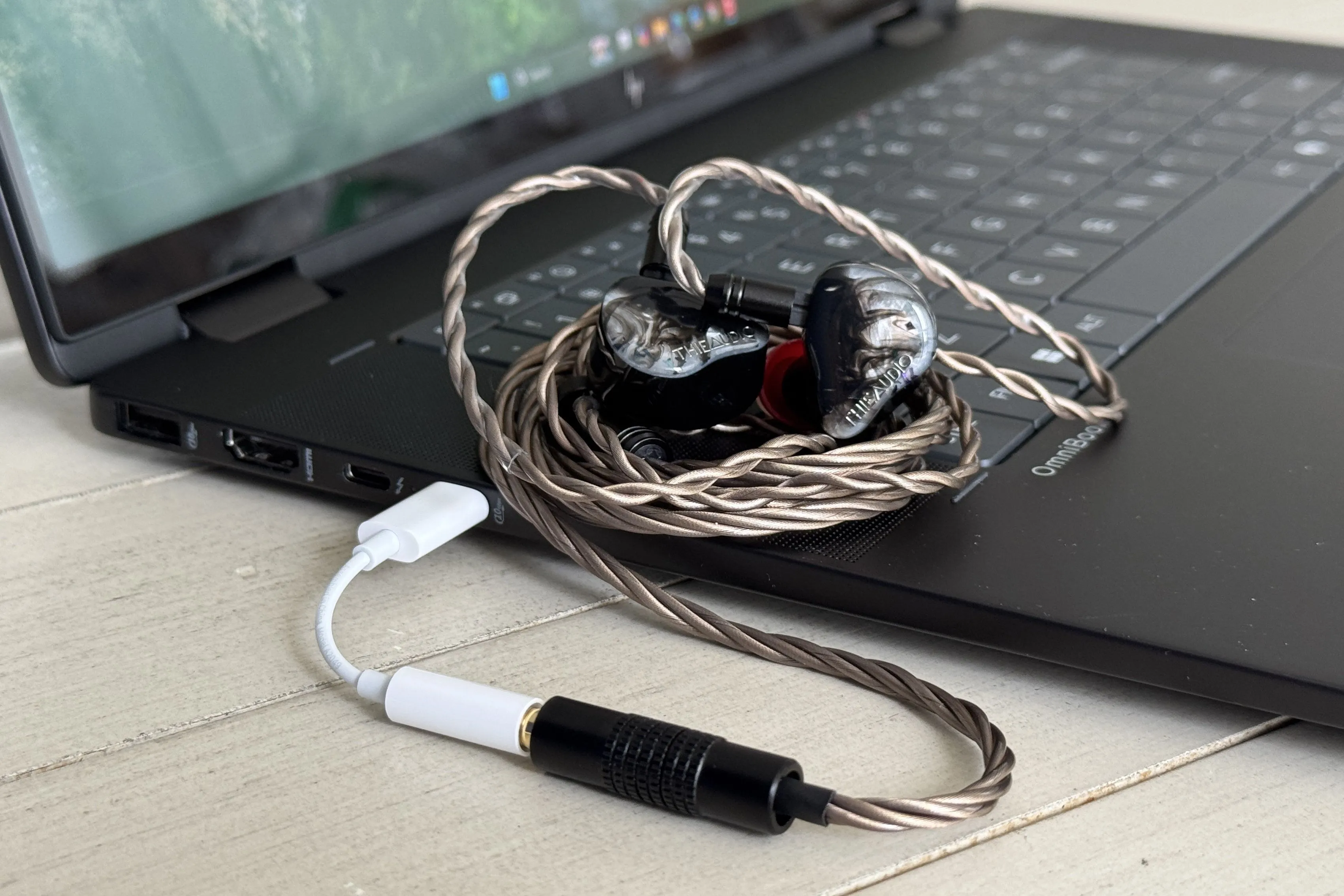 Bộ chuyển đổi Apple USB-C sang 3.5mm được kết nối với tai nghe cao cấp, nhấn mạnh hiệu suất vượt trội của thiết bị DAC giá rẻ này.
