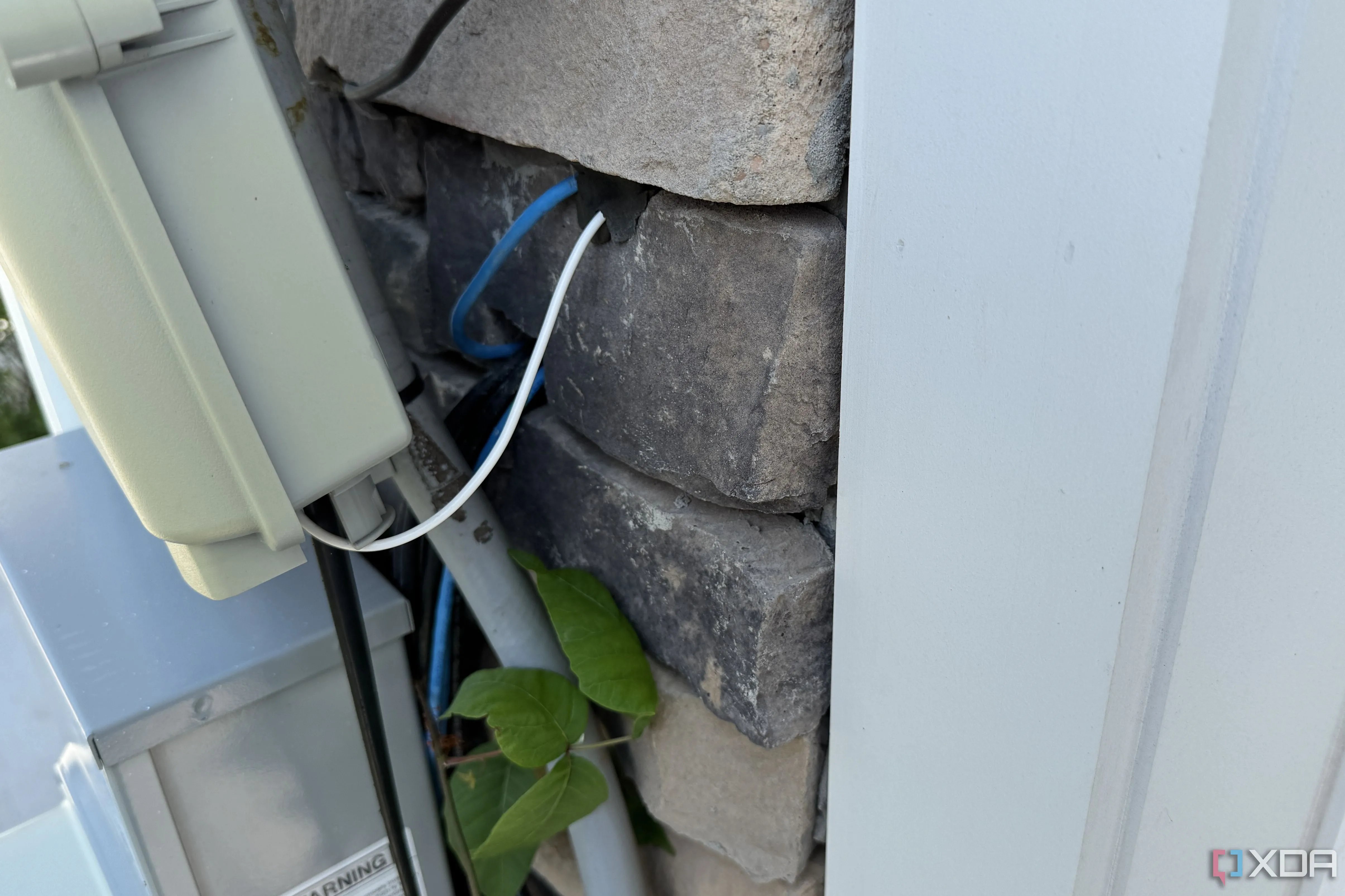 Cáp internet và dây đồng trục bị cuộn lại và treo lủng lẳng bên ngoài ngôi nhà mới xây
