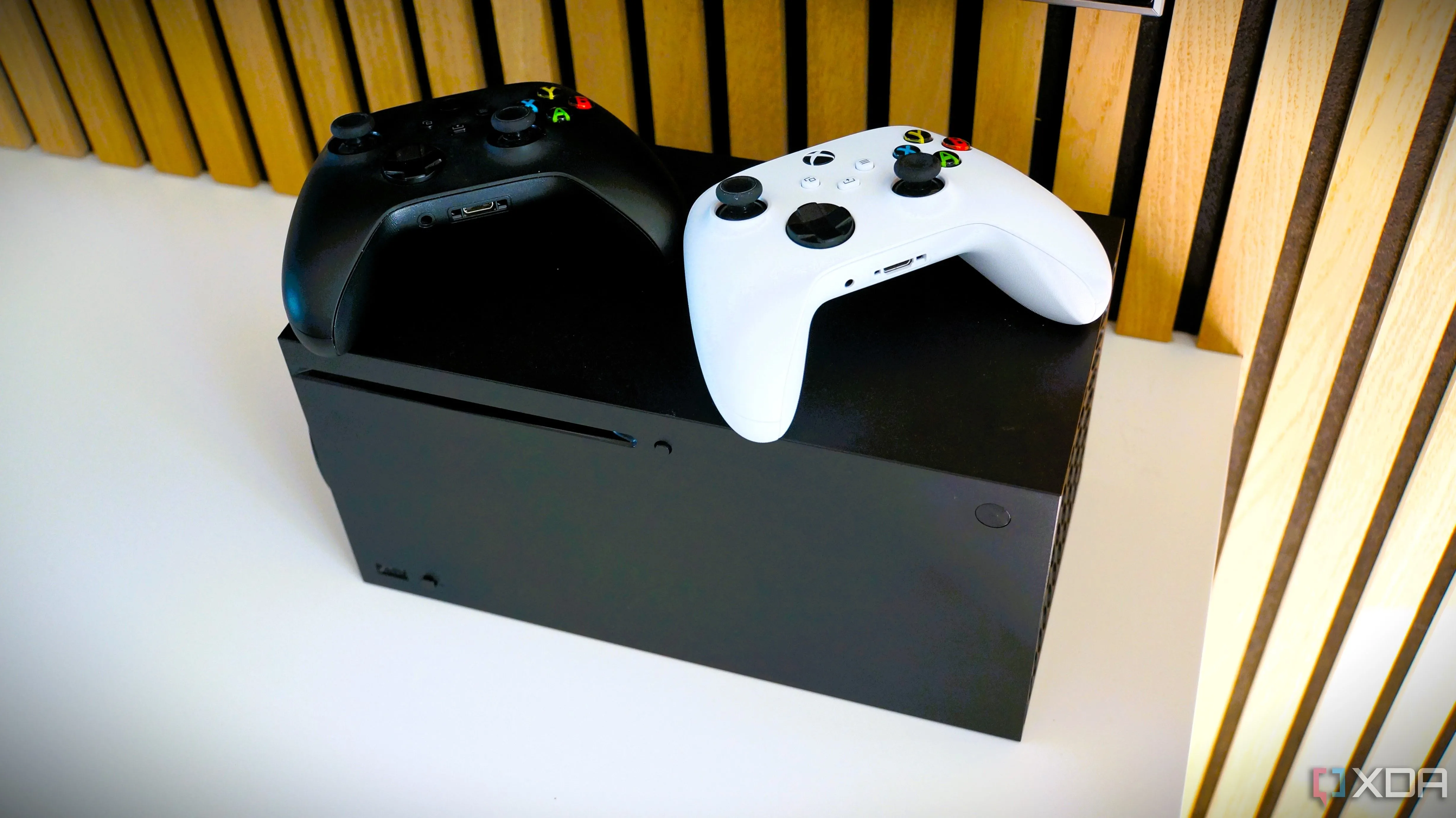 Console Xbox Series X với bộ điều khiển màu đen và trắng, biểu tượng của nỗ lực tương thích ngược của Xbox.