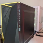 Mặt bên của một máy tính chơi game với vỏ case màu đen, có kính trong suốt để lộ linh kiện và đèn RGB