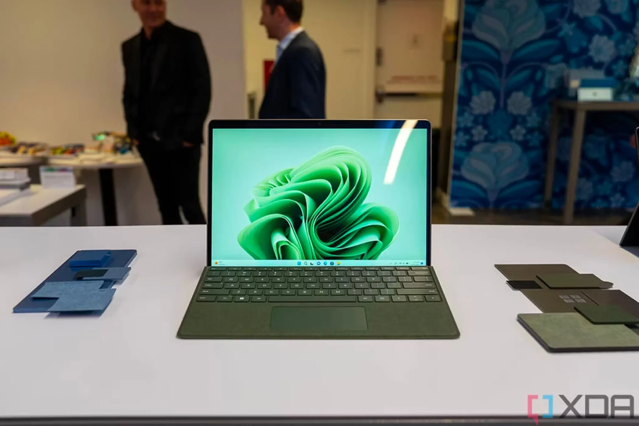 Microsoft Surface Pro màu xanh Forest với bàn phím Type Cover đi kèm, đặt trên bàn trắng.