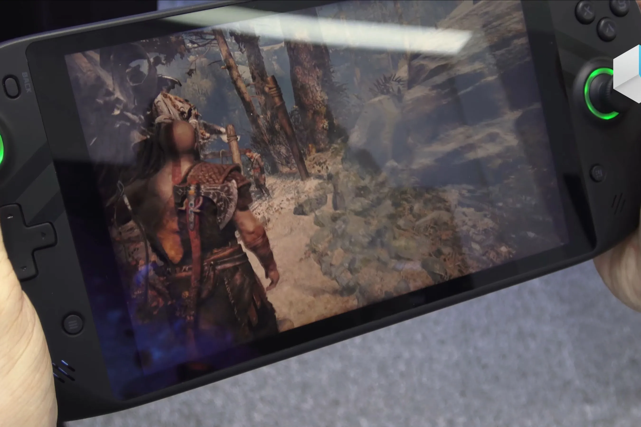 Một thiết bị chơi game cầm tay chạy tựa game God of War, thể hiện khả năng tương thích của game trên nền tảng di động.