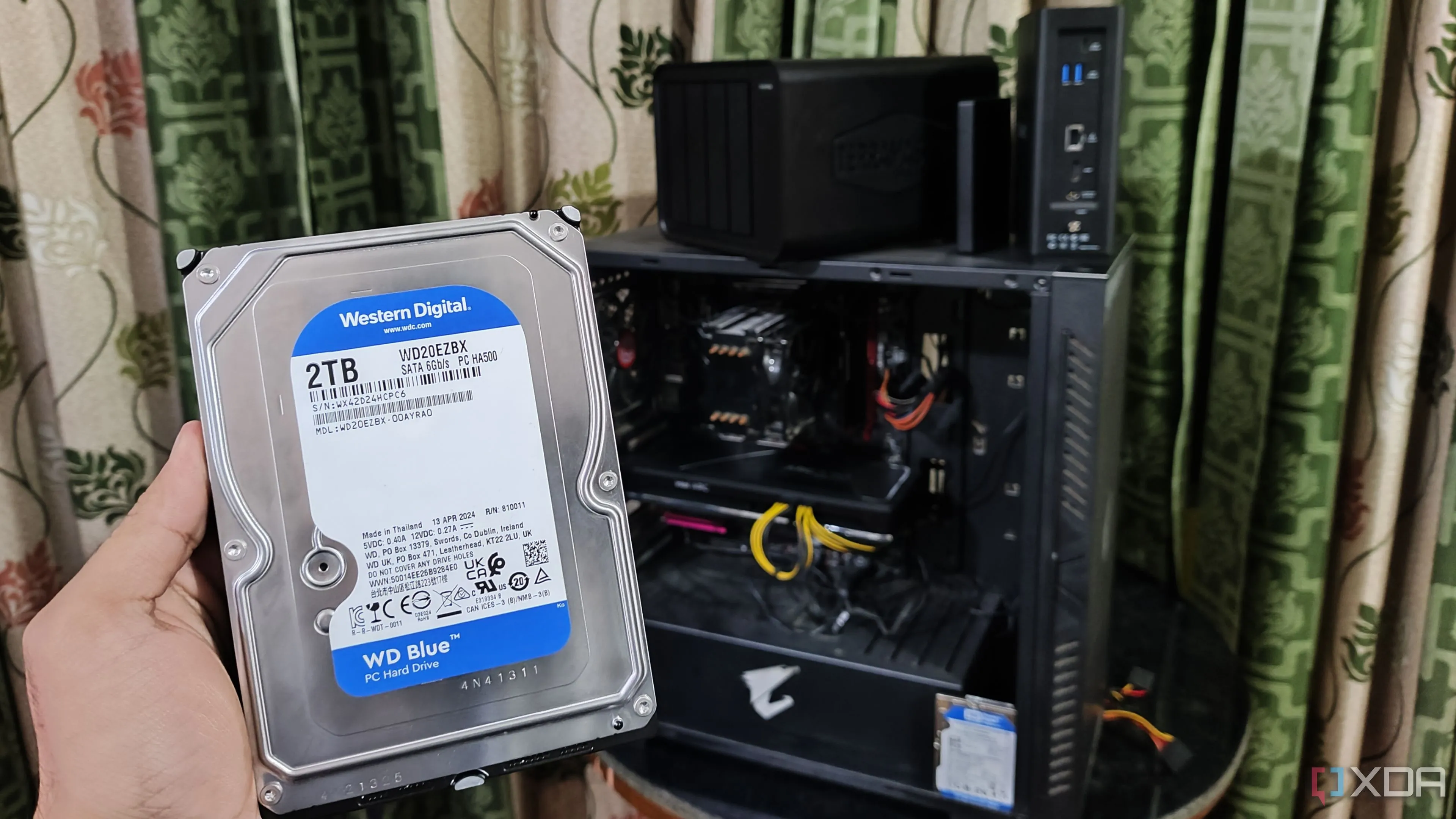 Người dùng đang cầm ổ cứng HDD để mở rộng dung lượng cho thiết bị NAS TerraMaster