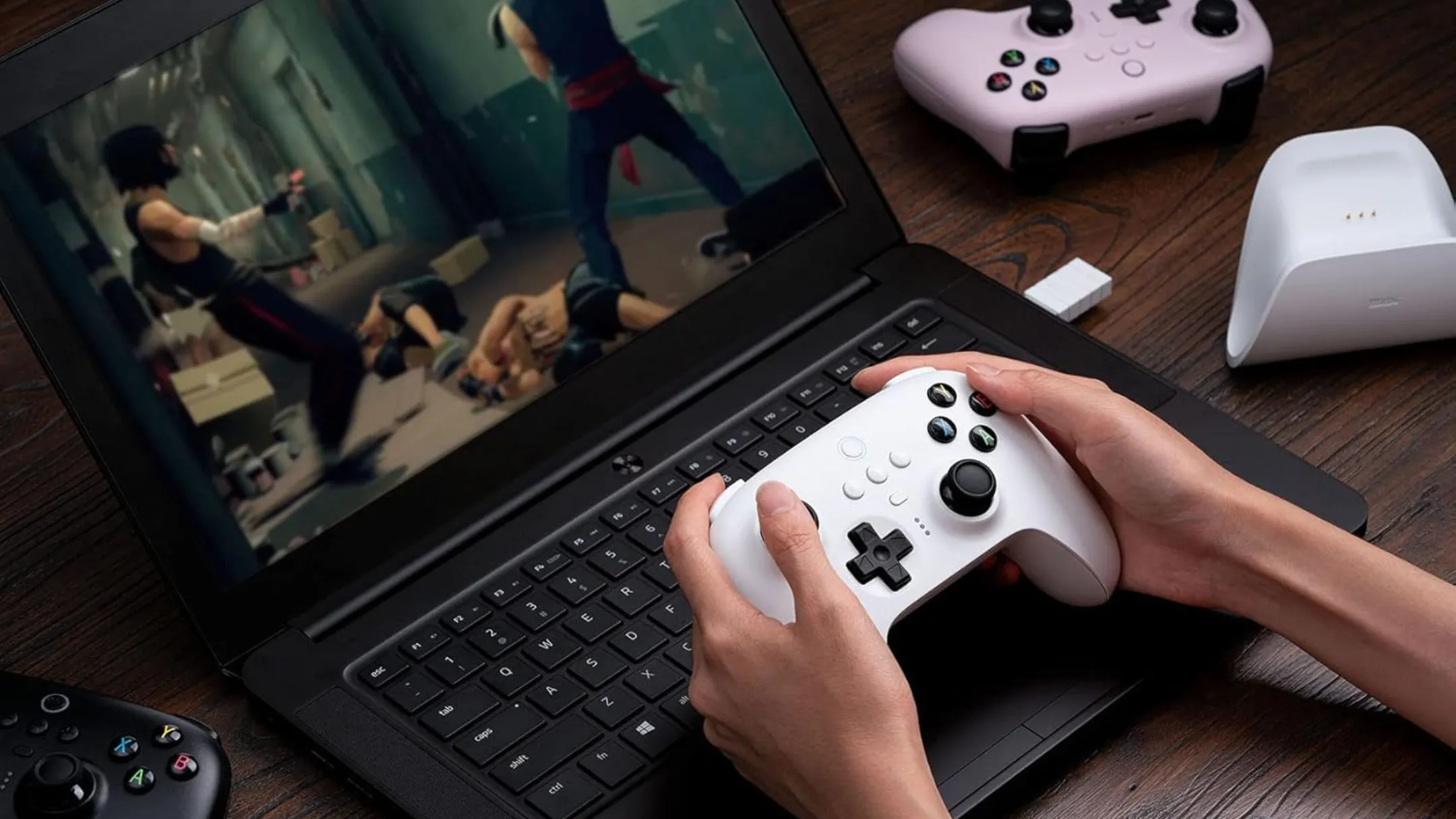 Người dùng đang trải nghiệm game trên laptop với tay cầm 8BitDo Ultimate Wireless