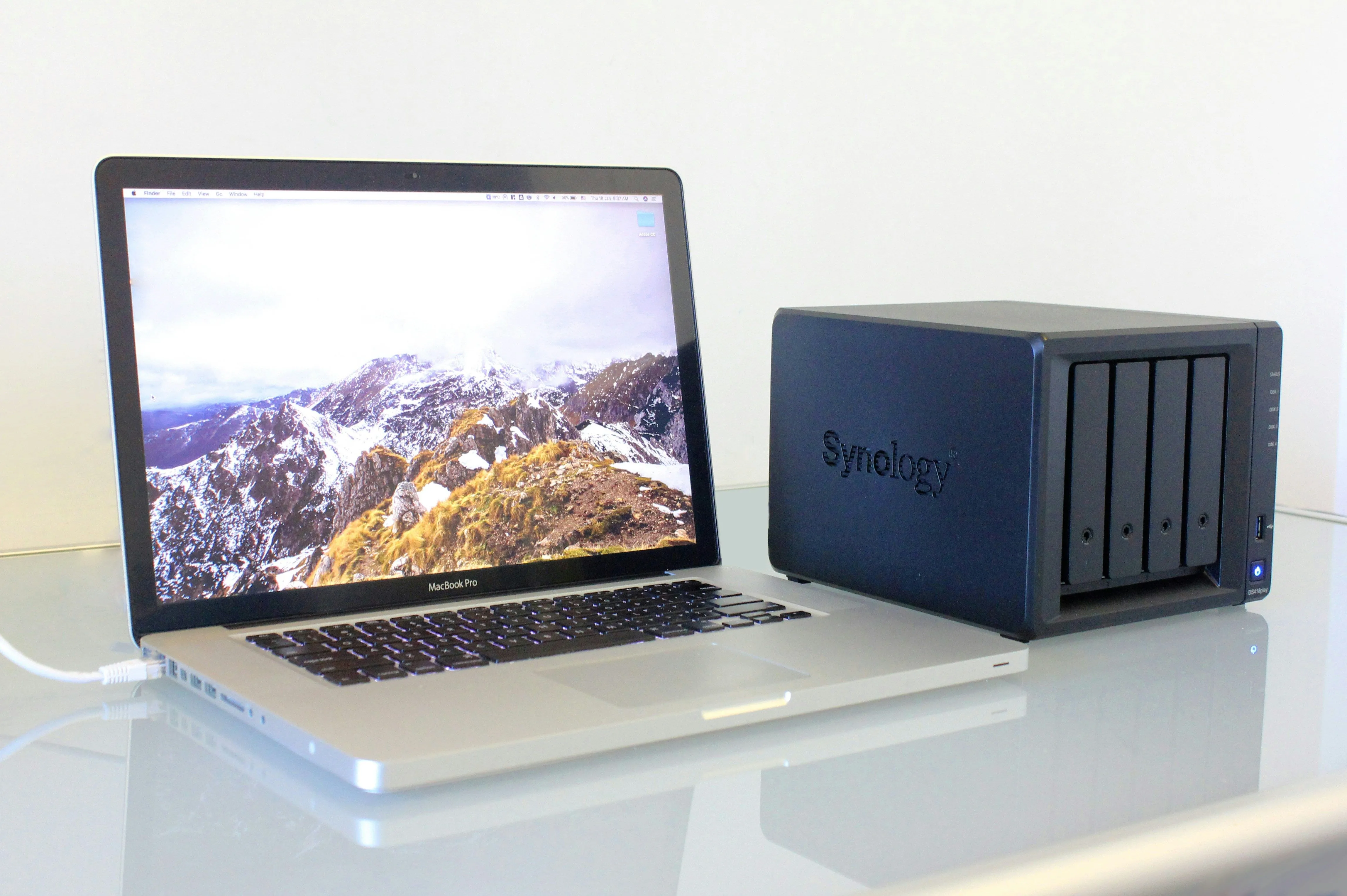 Người dùng làm việc với MacBook Pro kết nối NAS Synology, minh họa khả năng quản lý phiên bản tệp và phục hồi dữ liệu.