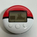 PokeWalker với hình ảnh Pokémon Dragonite hiển thị trên màn hình, minh họa thiết bị đếm bước chân kèm game Pokémon.