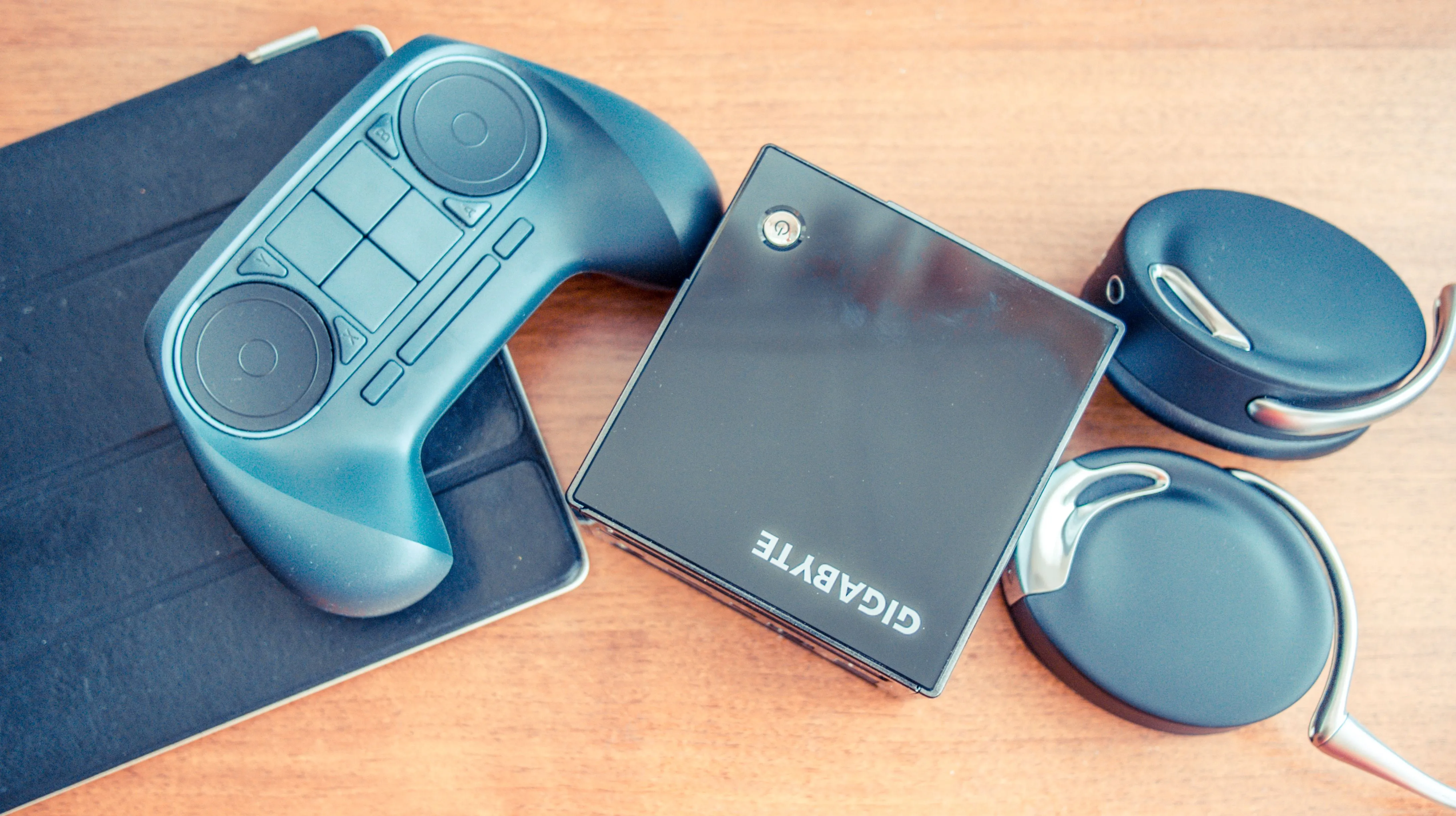 Tay cầm Steam Controller thế hệ cũ đặt trên một mẫu Steam Machine do Gigabyte sản xuất, minh họa cho nỗ lực đầu tiên của Valve trong việc đưa game PC lên màn hình TV.