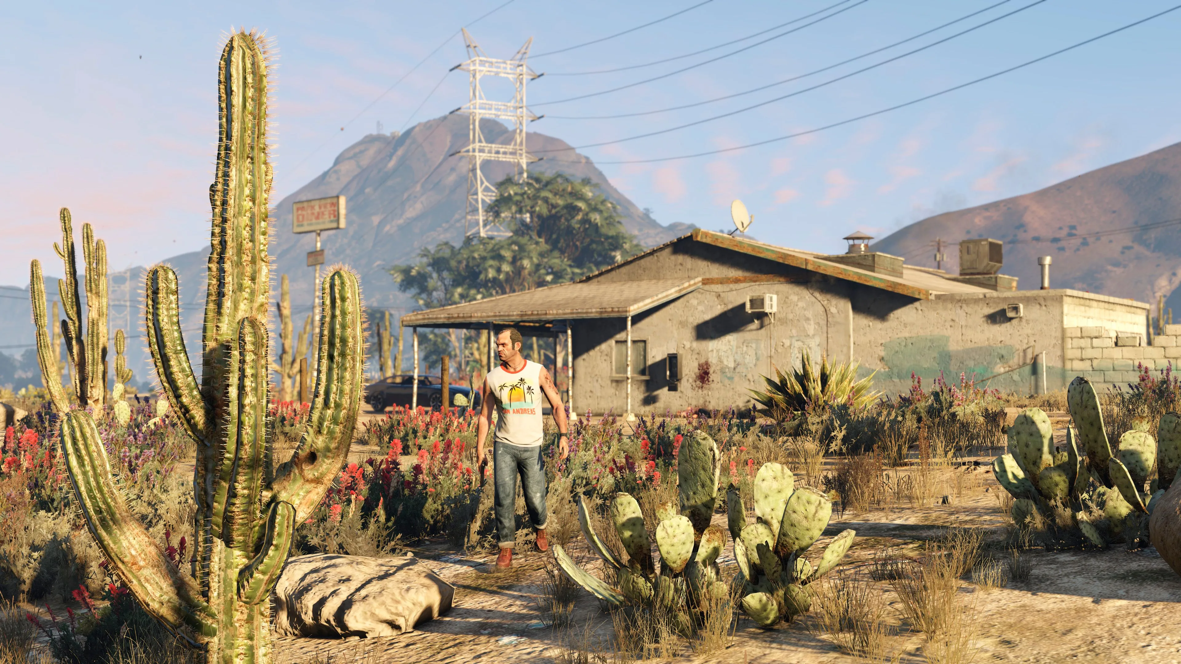 Trevor đang đi bộ trước một ngôi nhà ở Blaine County, phản ánh sự rộng lớn của môi trường game